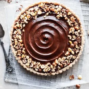 Flatlay of chocolate hazelnut tart on a cooling rack