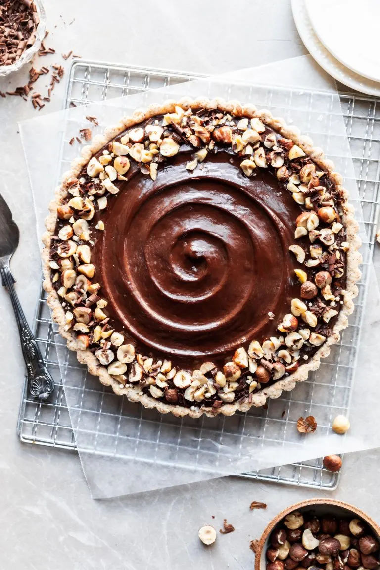 Flatlay of chocolate hazelnut tart on a cooling rack