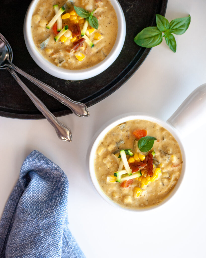Flat lay of 2 bowls of vegan corn and zucchini chowder