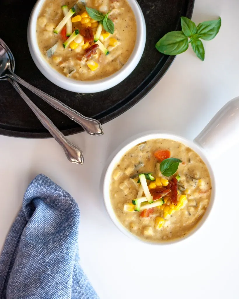 Flat lay of 2 bowls of vegan corn and zucchini chowder