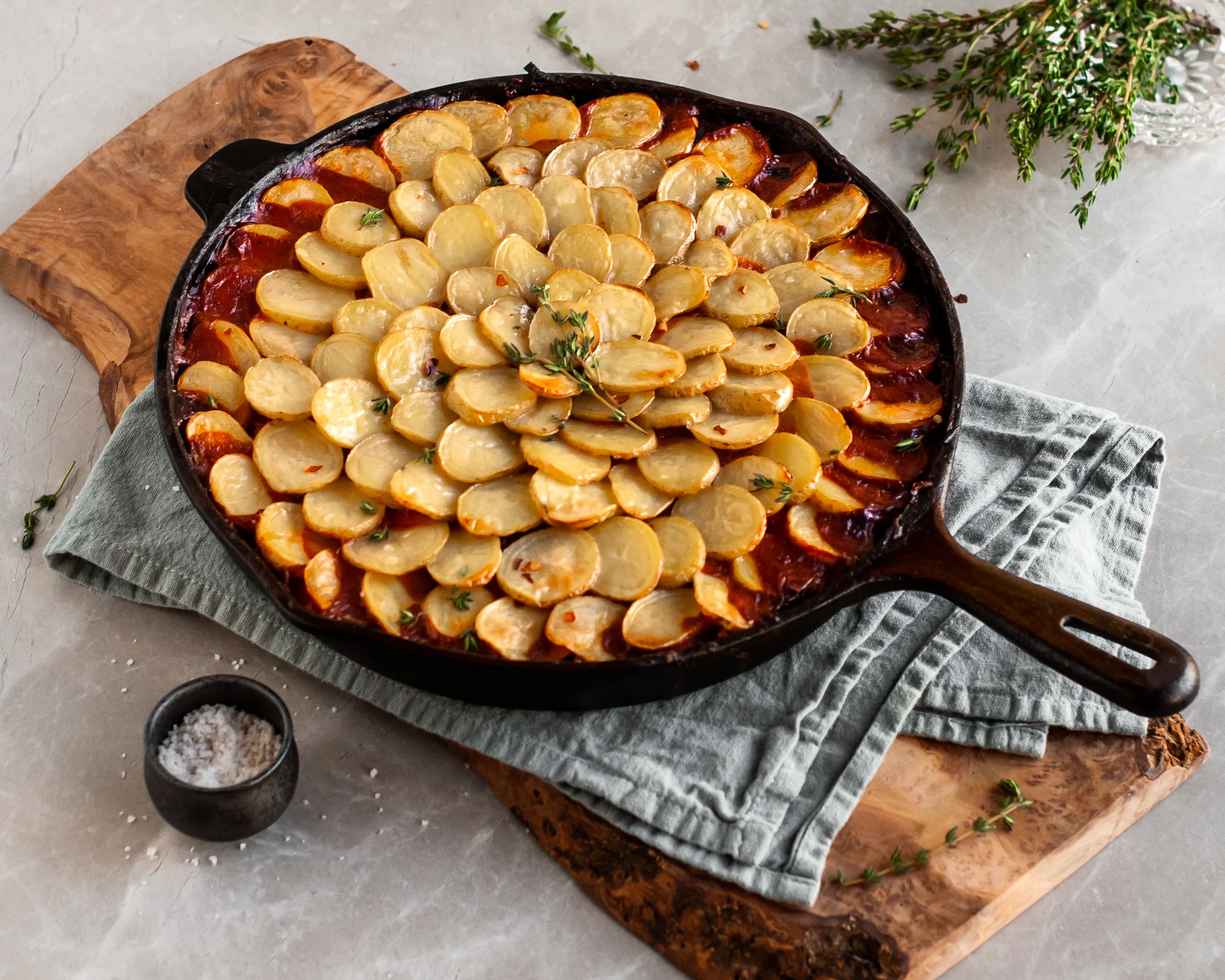 Vegan Savory Skillet Stew with Baby Potato Topping cooling on tea towel over wood slab
