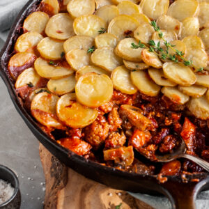 Vegan Savory Skillet Stew with Baby Potato Topping being served from skillet