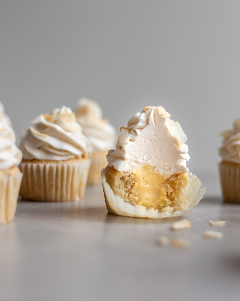 Vegan Coconut Cream Cupcakes cut in half revealing the custard center