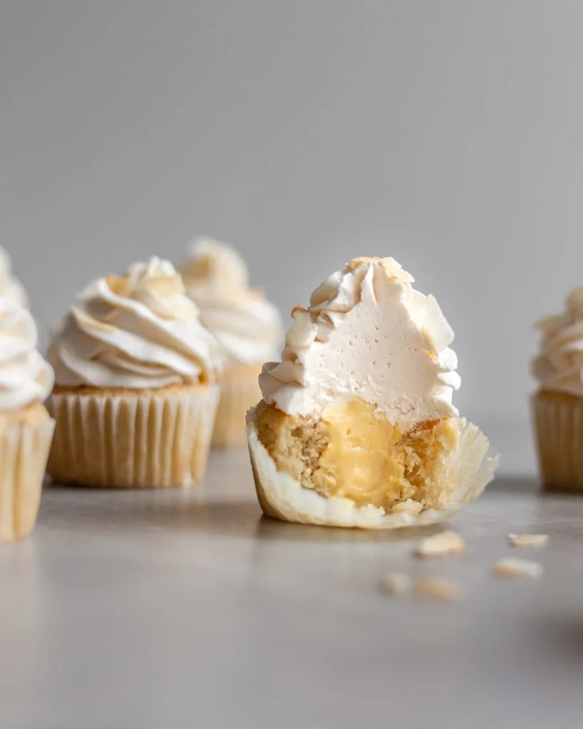 Vegan Coconut Cream Cupcakes cut in half revealing the custard center