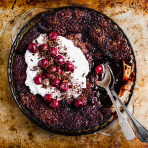 Vegan Saucy Cherry Chocolate Fudge Cake served with coconut whipped cream and morello cherries