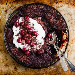 Vegan Saucy Cherry Chocolate Fudge Cake served with coconut whipped cream and morello cherries