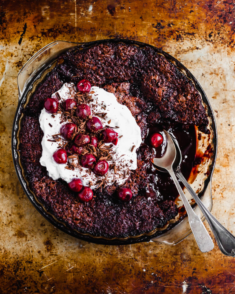 Vegan Saucy Cherry Chocolate Fudge Cake served with coconut whipped cream and morello cherries