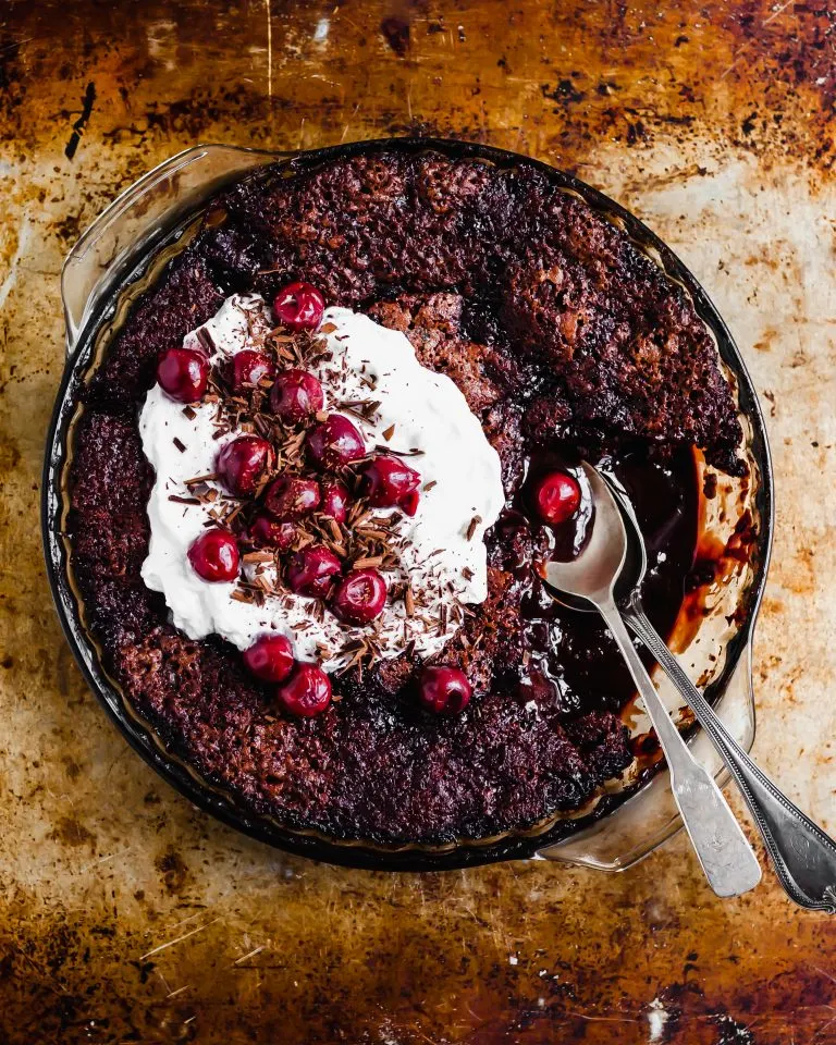 Vegan Saucy Cherry Chocolate Fudge Cake served with coconut whipped cream and morello cherries