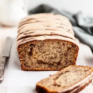 Vegan Cinnamon Swirl Banana Bread glazed, with one slice made