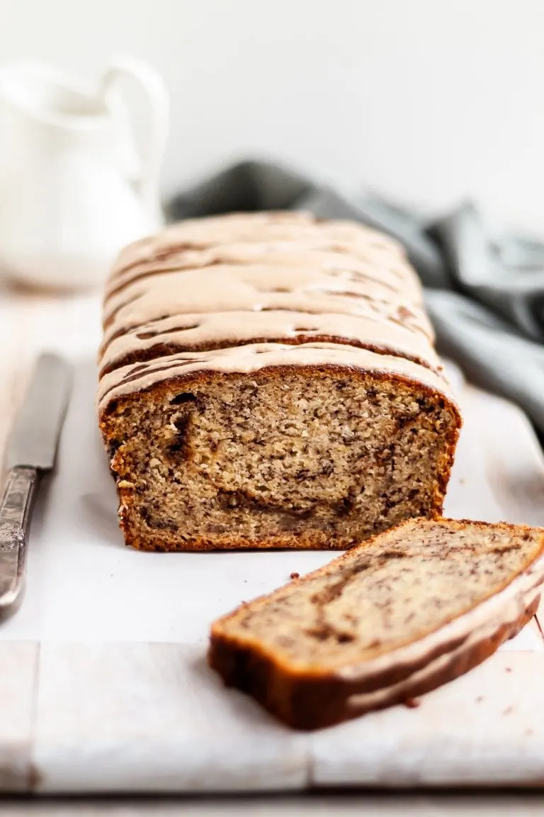 Vegan Cinnamon Swirl Banana Bread glazed, with one slice made