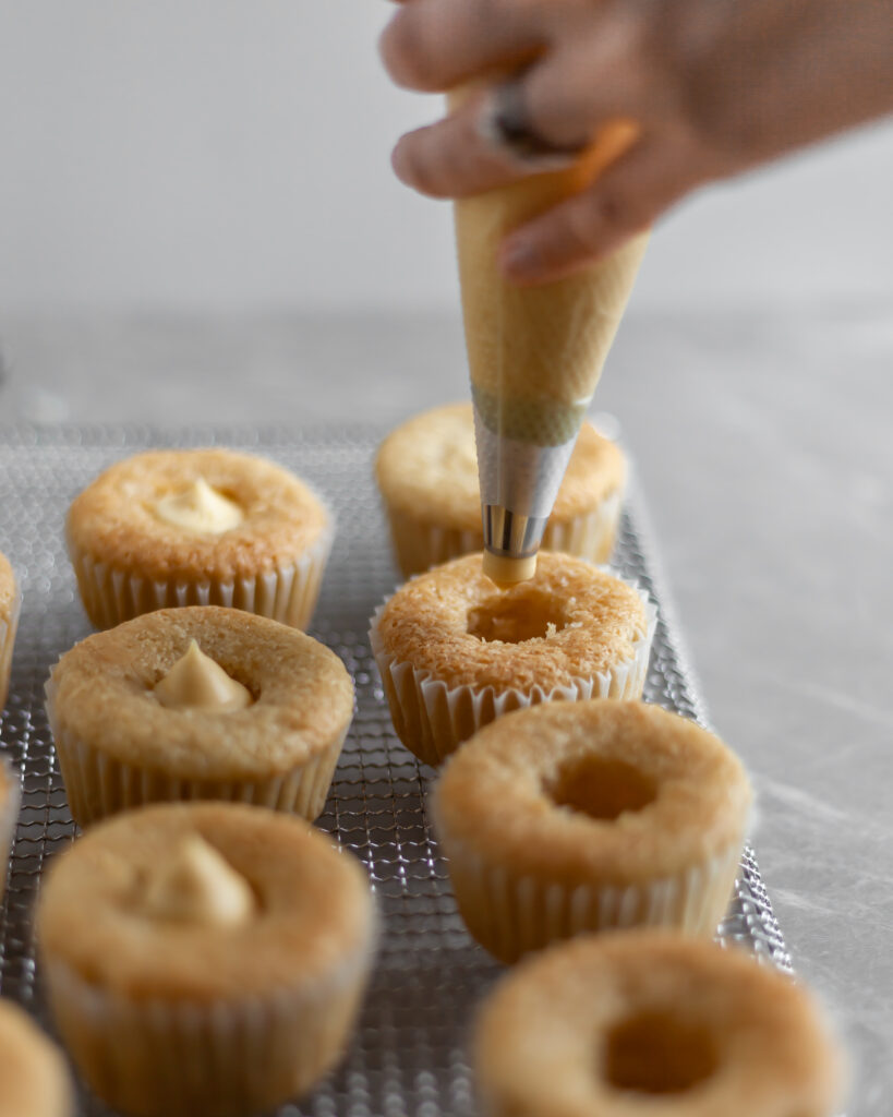 Vegan Coconut Cream Cupcakes being filled with custard