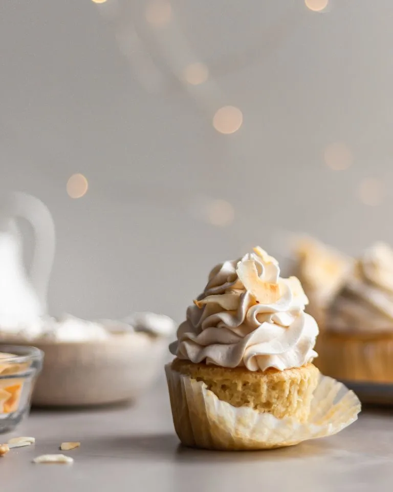 Vegan Coconut Cream Cupcake with the cupcake liner being removed
