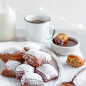 Fresh Vegan Beignets served with powdered sugar, chocolate sauce and coffee