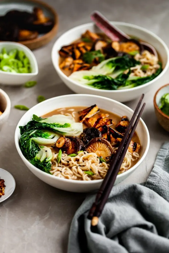 2 bowls of mushroom miso ramen and a few bowls of garnishes