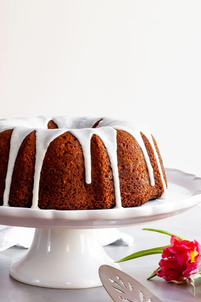 Vegan Hummingbird Cake with Vanilla Glaze, ready to be topped with chopped pecans