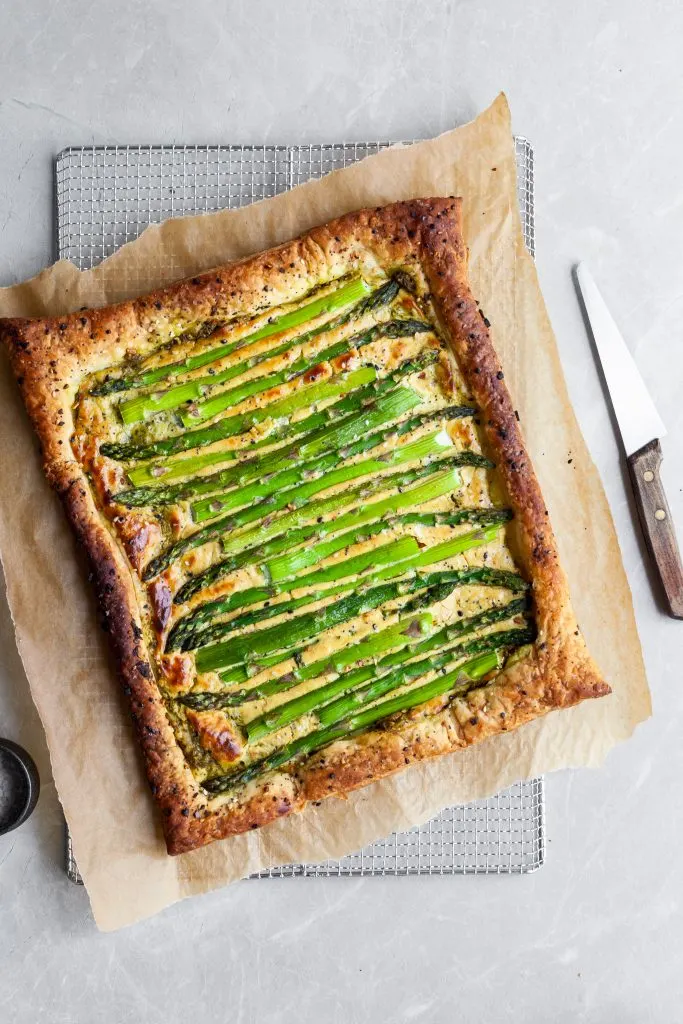 Vegan Asparagus and Pesto Cashew Cheese Tart with Lemon Arugula on cooling rack before arugula salad is added