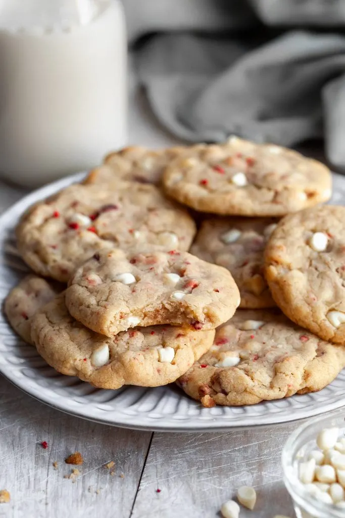 Vegan Strawberries & Cream Chewy Cookies on a plate with a bite taken out of one revealing the chewy interior