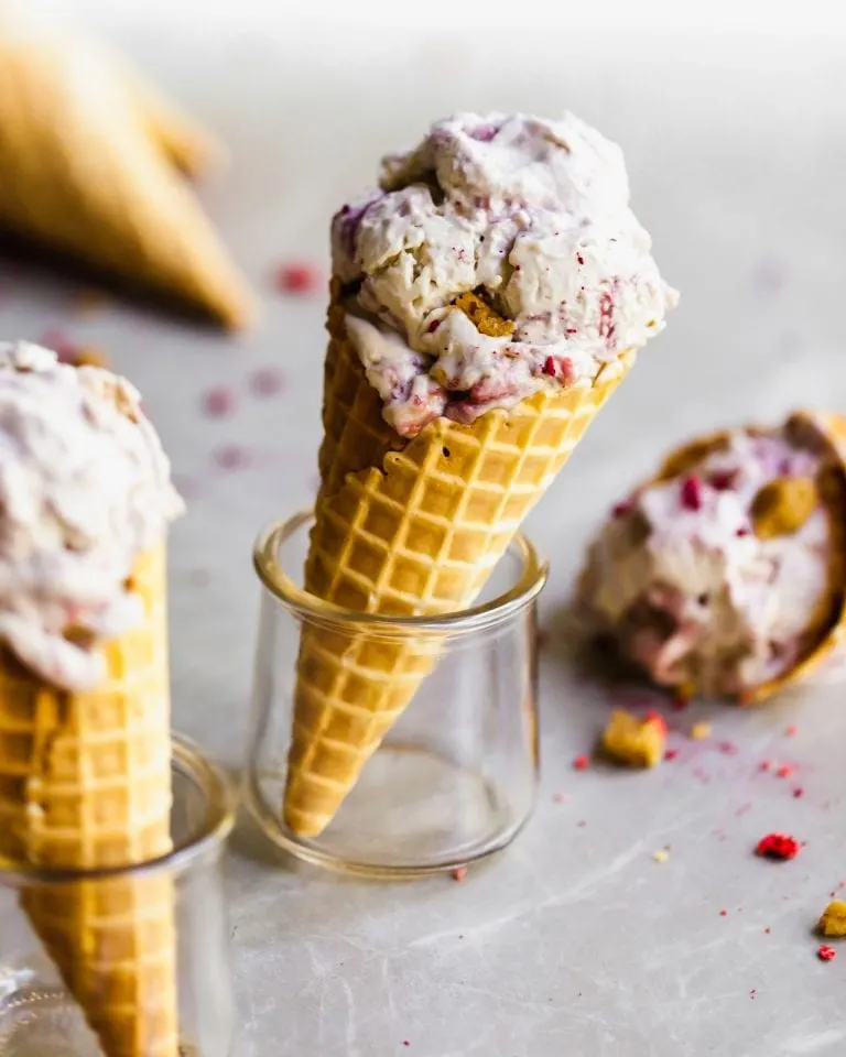 Vegan Strawberry Rhubarb Crumble Ice Cream in a waffle cone, set in a glass and other cones around it