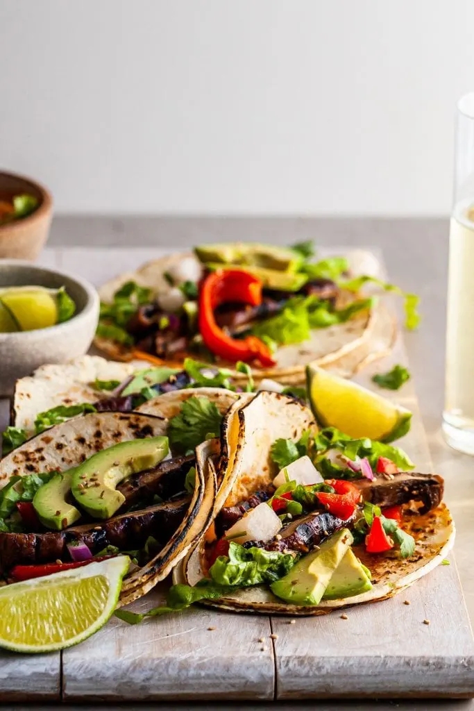 Close up of Korean Portobello Taco served with lime wedges