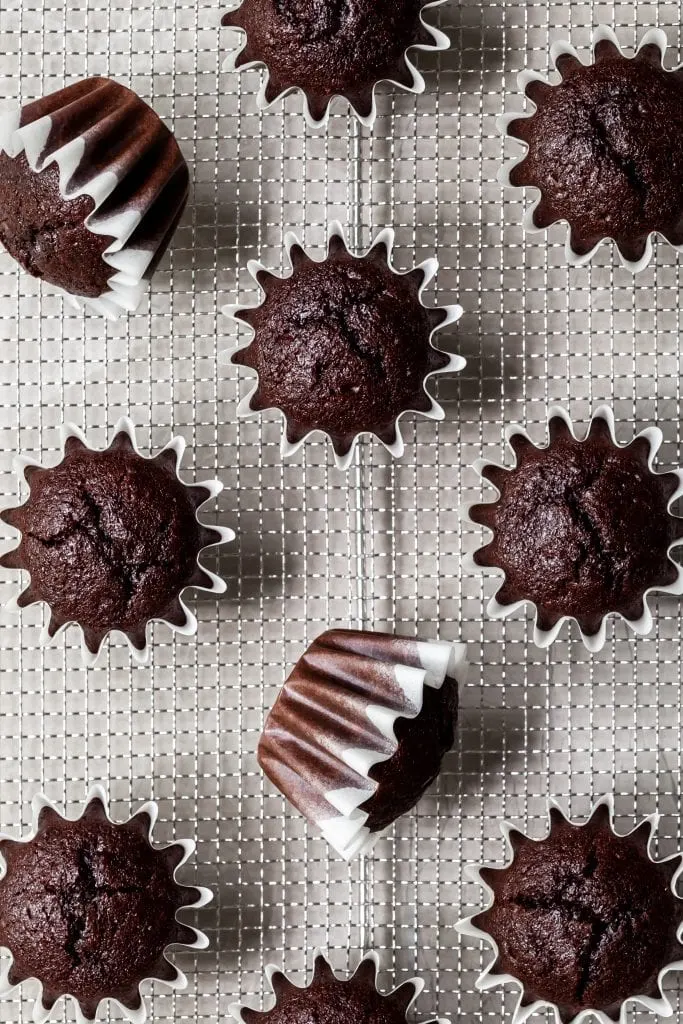Unfrosted cupcake bases on a cooling rack, view from above