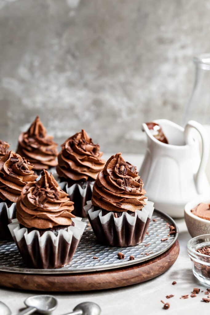 A tray of 6 frosted chocolate cupcakes with whipped chocoalte ganache frsoting