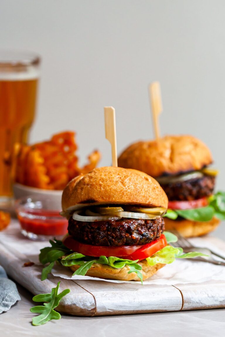 Vegan burger served in a toasted bun with pickles, sliced onions, lettuce and tomatoes.
