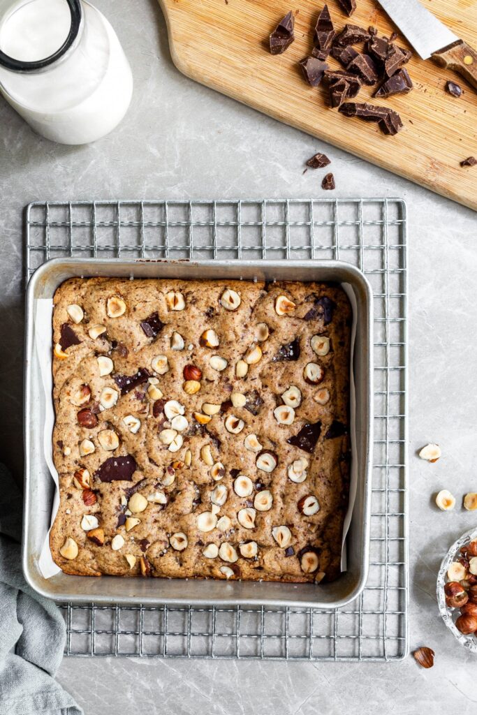 Pan of vegan chocolate chunk hazelnutblondies on a cooling rack before being cut