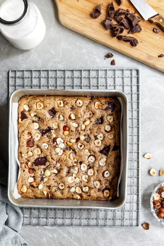 Pan of vegan chocolate chunk hazelnutblondies on a cooling rack before being cut