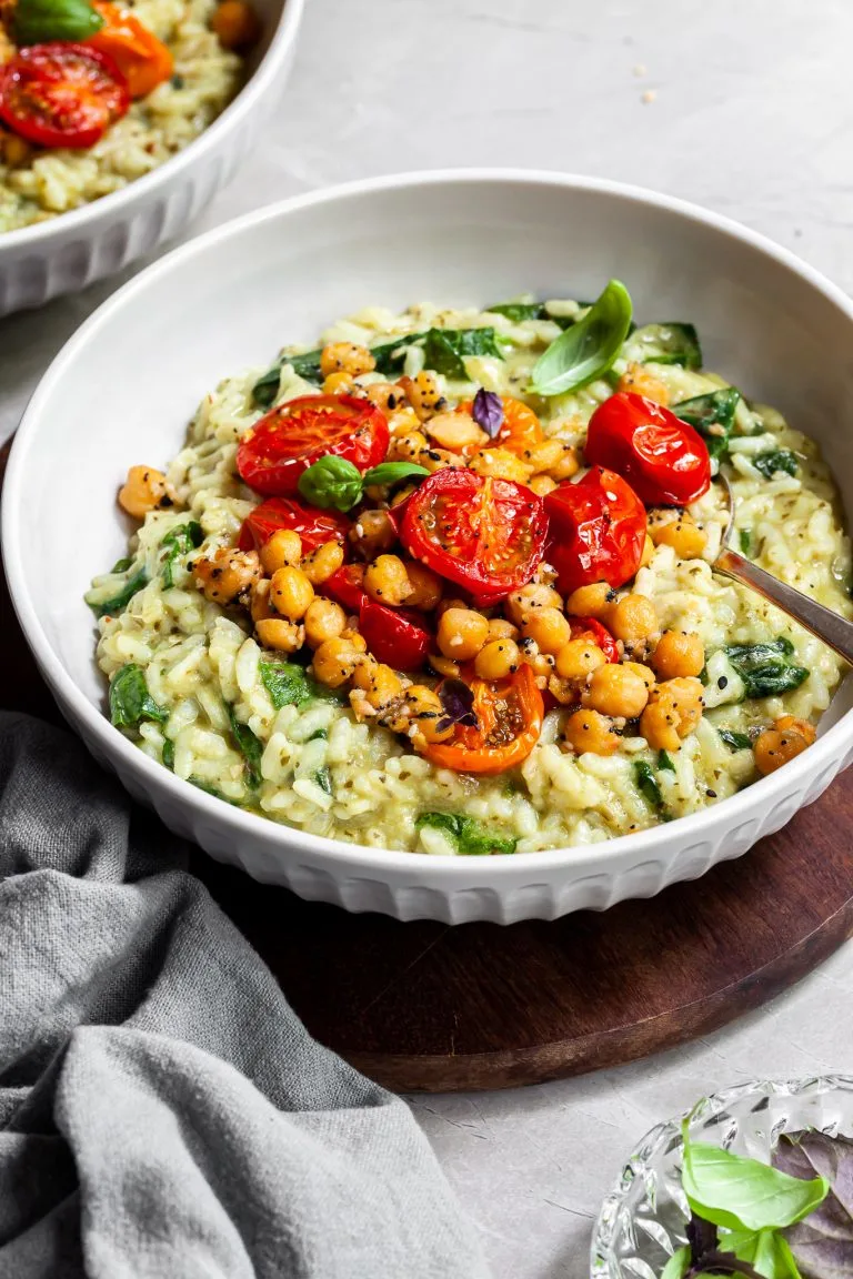 Bowl of risotto toppped with roasted cherry tomatoes and chickpeas which are covered in Everything Spice