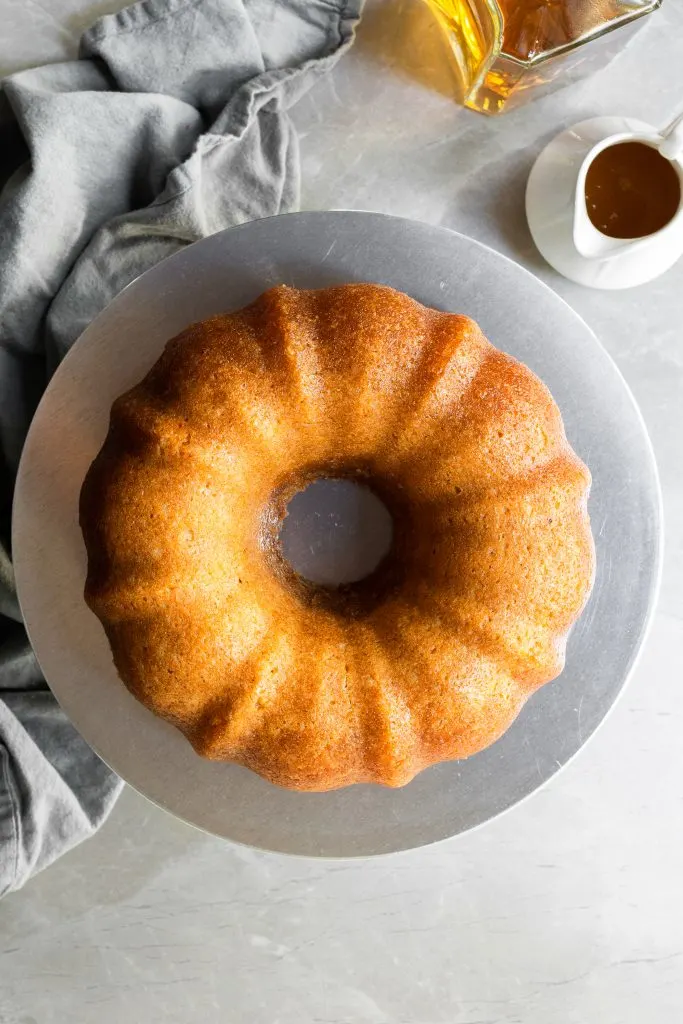 Top down view of rum cake on a cake stand just before being sliced