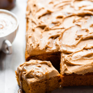 Sheet cake with swirled frosting served with a pumpkin spice latte and butterscotch sauce