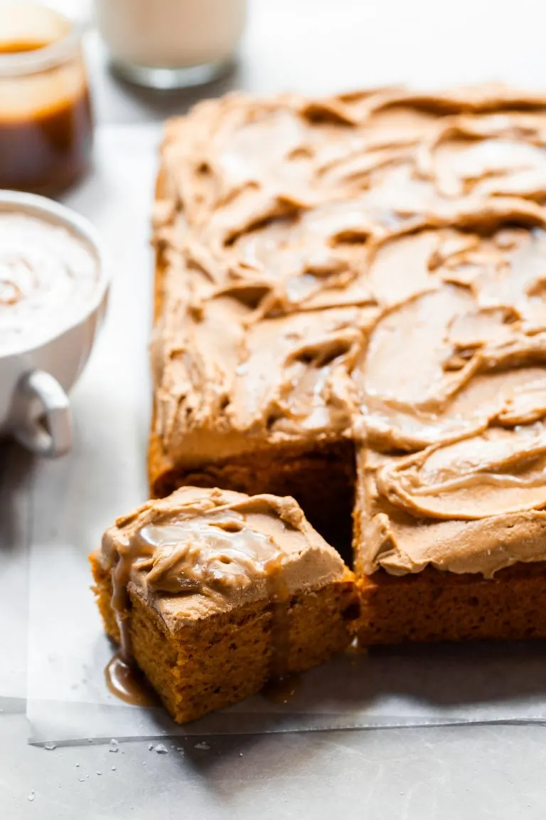 Sheet cake with swirled frosting served with a pumpkin spice latte and butterscotch sauce