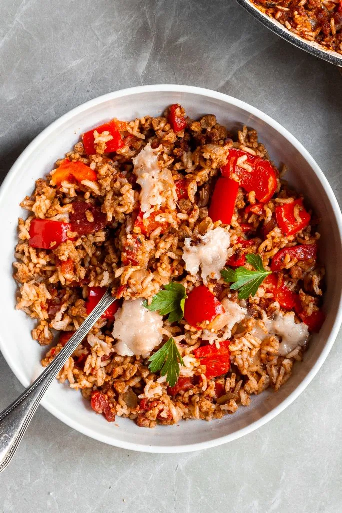 A white bowl filling with capsicum and rice bake