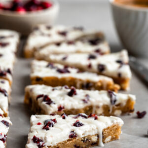 Vegan Cranberry Bliss Bars, cut into triangles and a cup of espresso in background