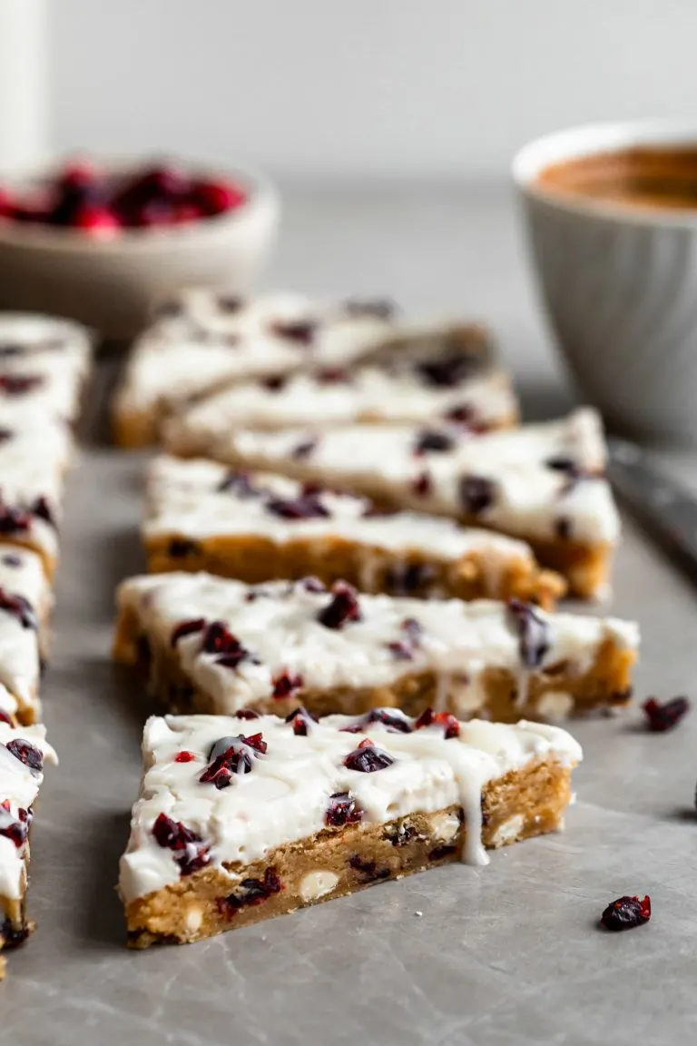 Vegan Cranberry Bliss Bars, cut into triangles and a cup of espresso in background