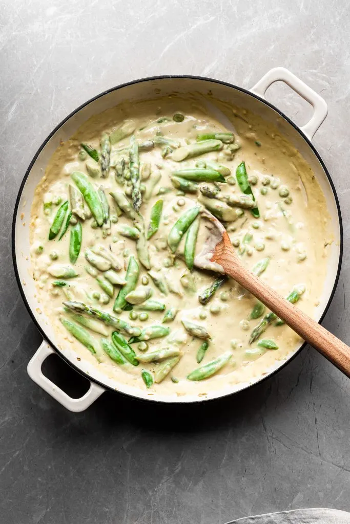Flat lay of asparagus and peas in a lemon cream sauce