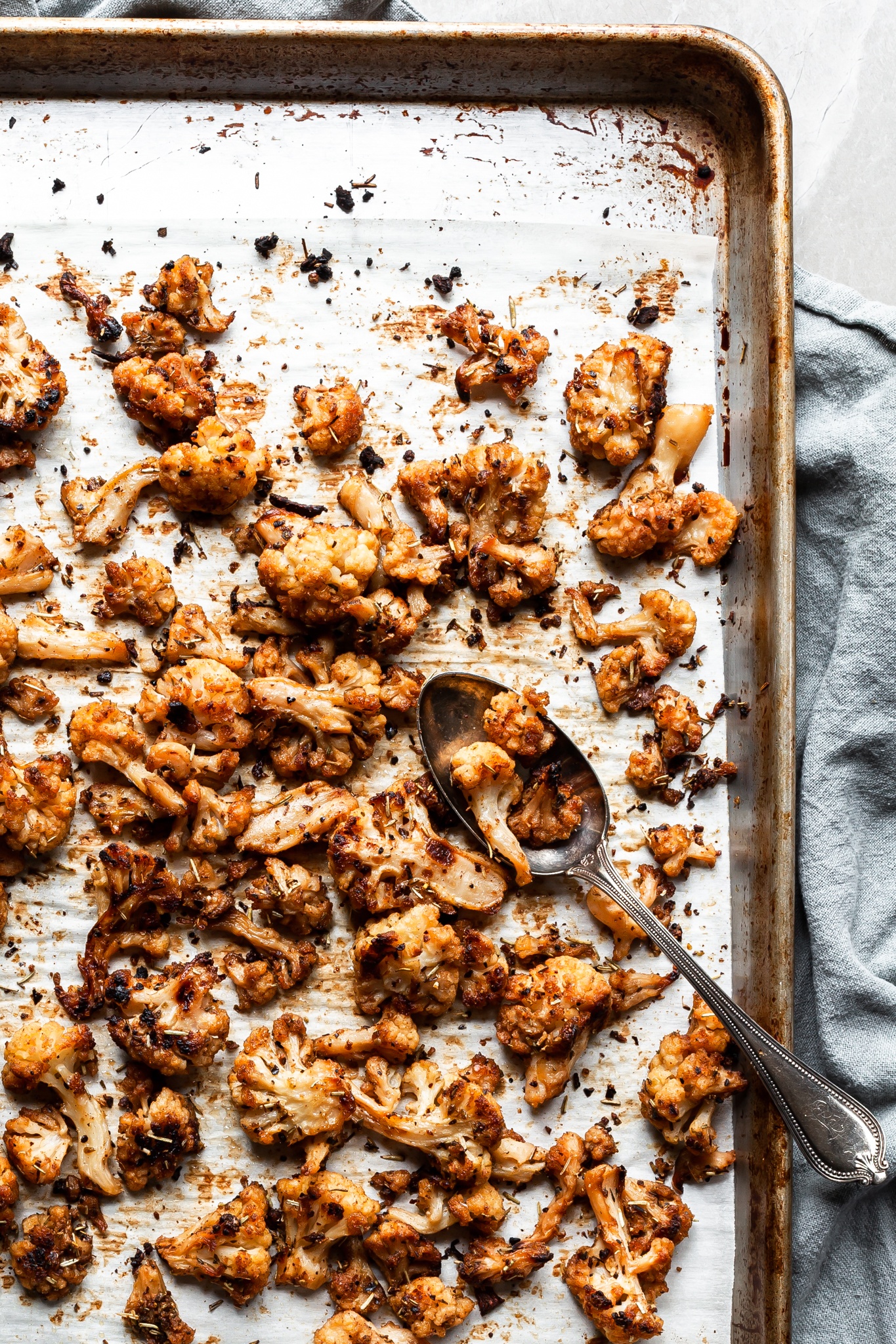 roasted cauliflower on a baking sheet - well caramelized and seasoned with Greek spices