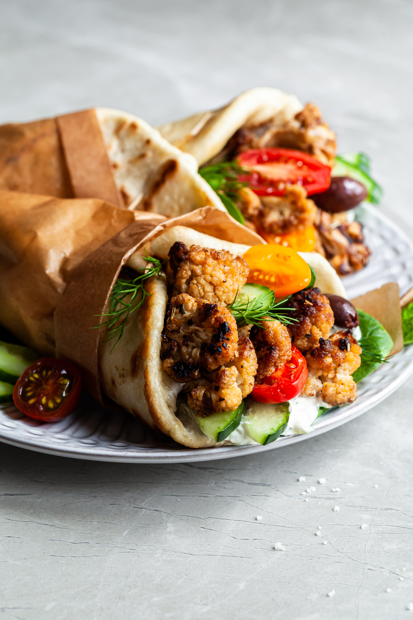 close up of a vegan cauliflower sandwich filled with fresh vegetables and a creamy dairy free dressing