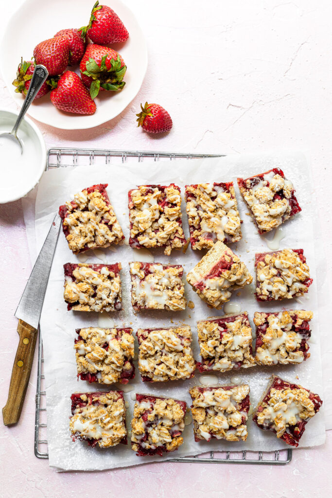 16 squares of strawberry crumb bars sitting on a wire cooling rack