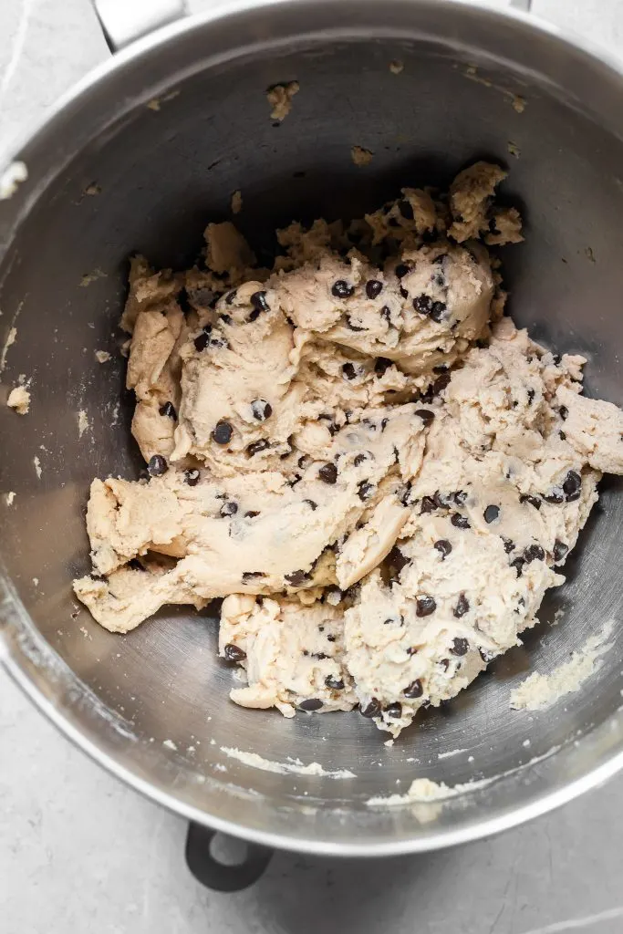 a silver bowl filled with chocolate chip cookie dough