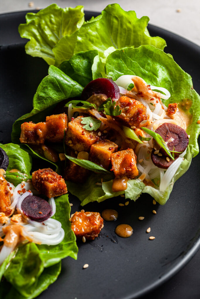 lettuce leaf filled with tofu, rice noodles, carrots and peanut sauce
