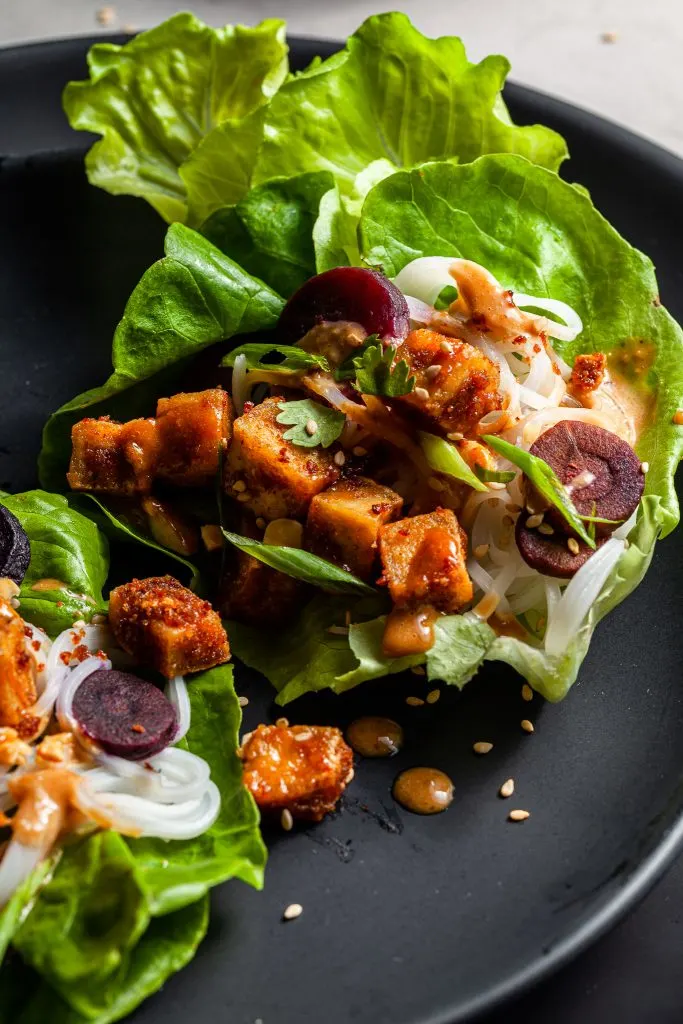 lettuce leaf filled with tofu, rice noodles, carrots and peanut sauce