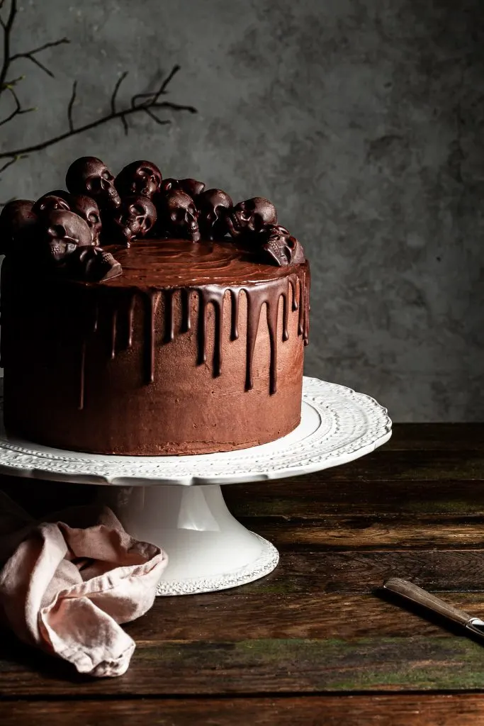 Cropped view of a chocolate layer cake covered in small chocolate skulls