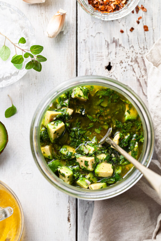 View looking down into a jar of avocado chimichurri sauce.