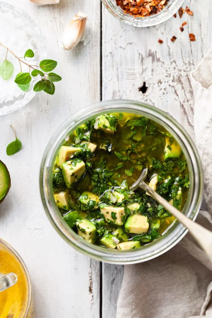 View looking down into a jar of avocado chimichurri sauce.