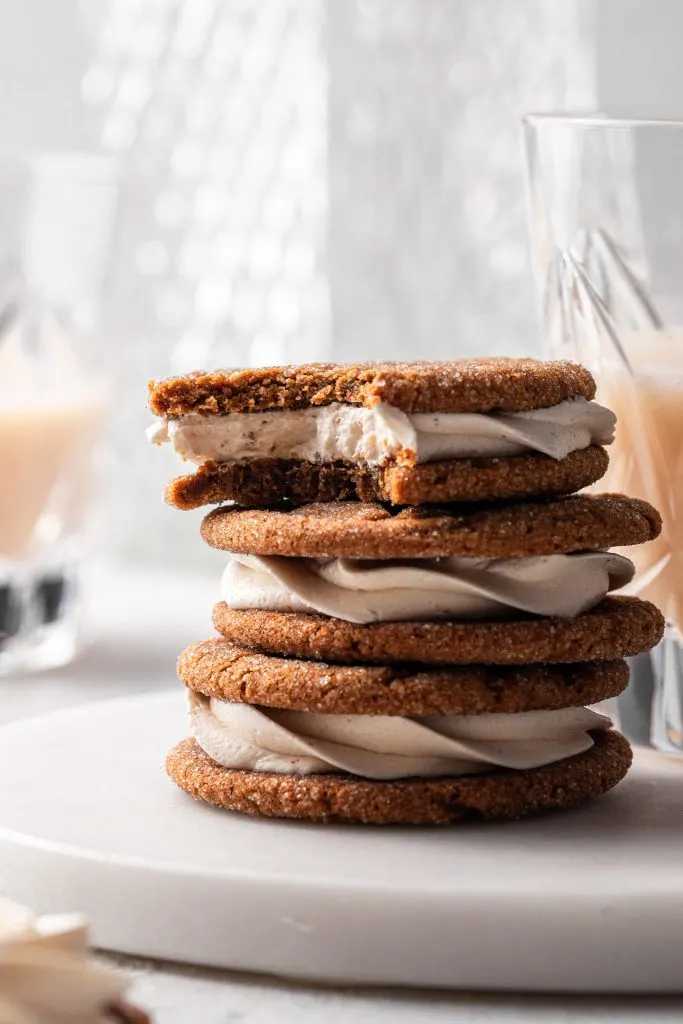 Three molasses sandwich cookies stacked with the top one missing a bite