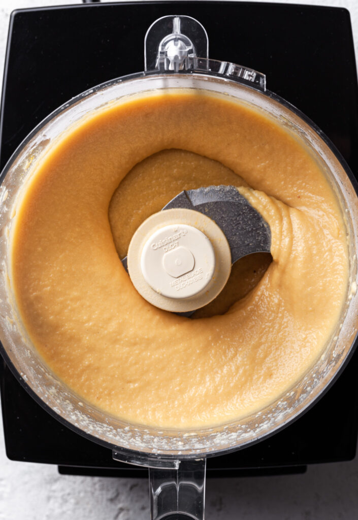 A food processor filled with a creamy yellow almond filling, or frangipane. 