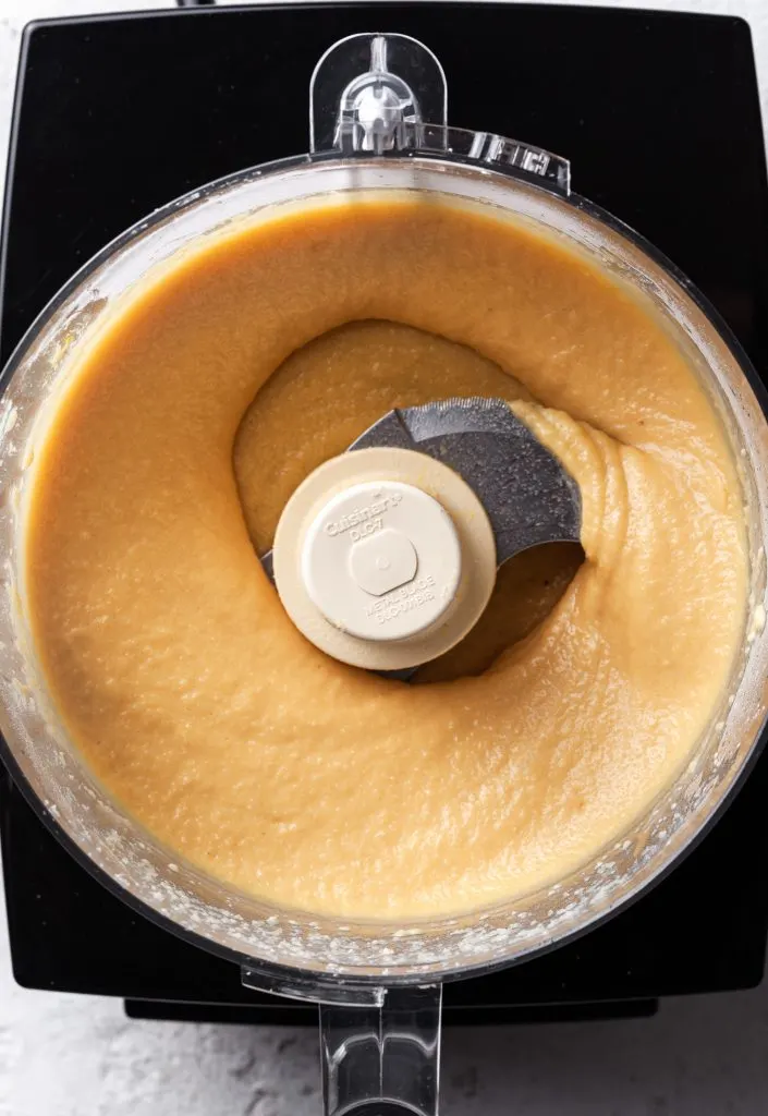 A food processor filled with a creamy yellow almond filling, or frangipane. 