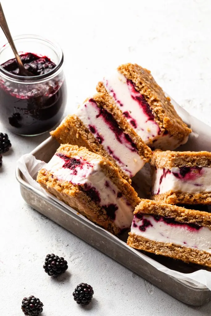 A small metal dish holds 5 ice cream bars, and a jar in the background contains purple jam. 
