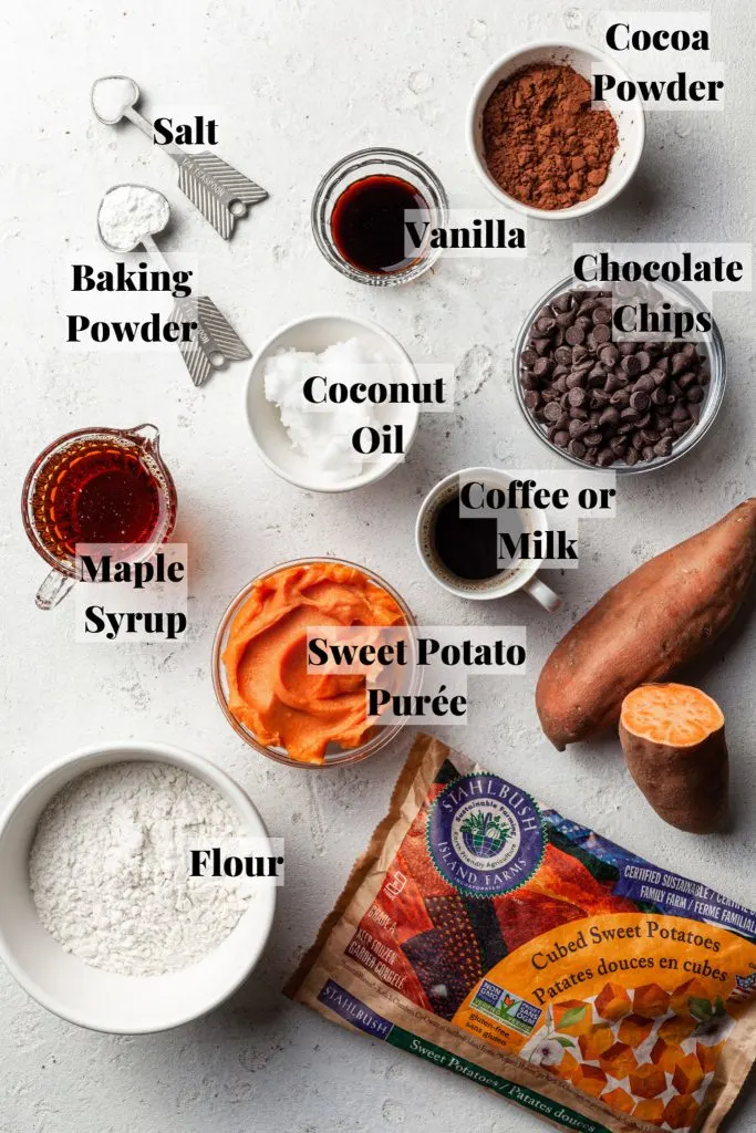 A white counter with labelled and measured ingredients in small clear glass bowls for making vegan sweet potato brownies.